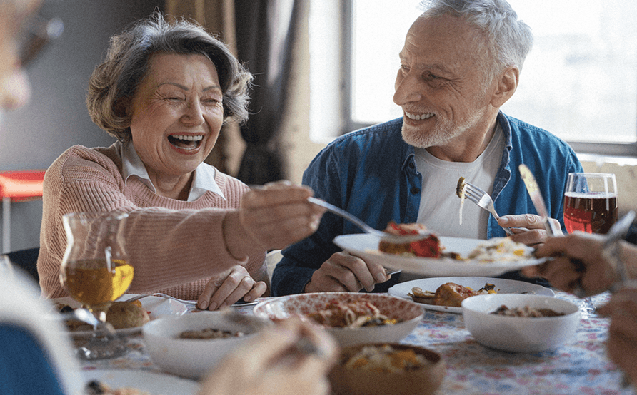 a senior couple enjoying food at the table