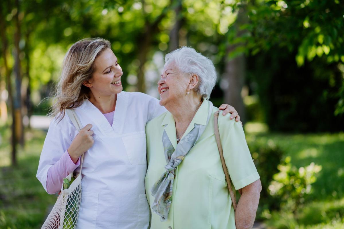 Caregiver and grandmother smiling at each other