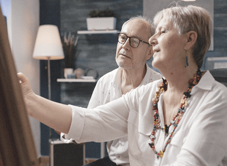 two senior couples looking at canvas together