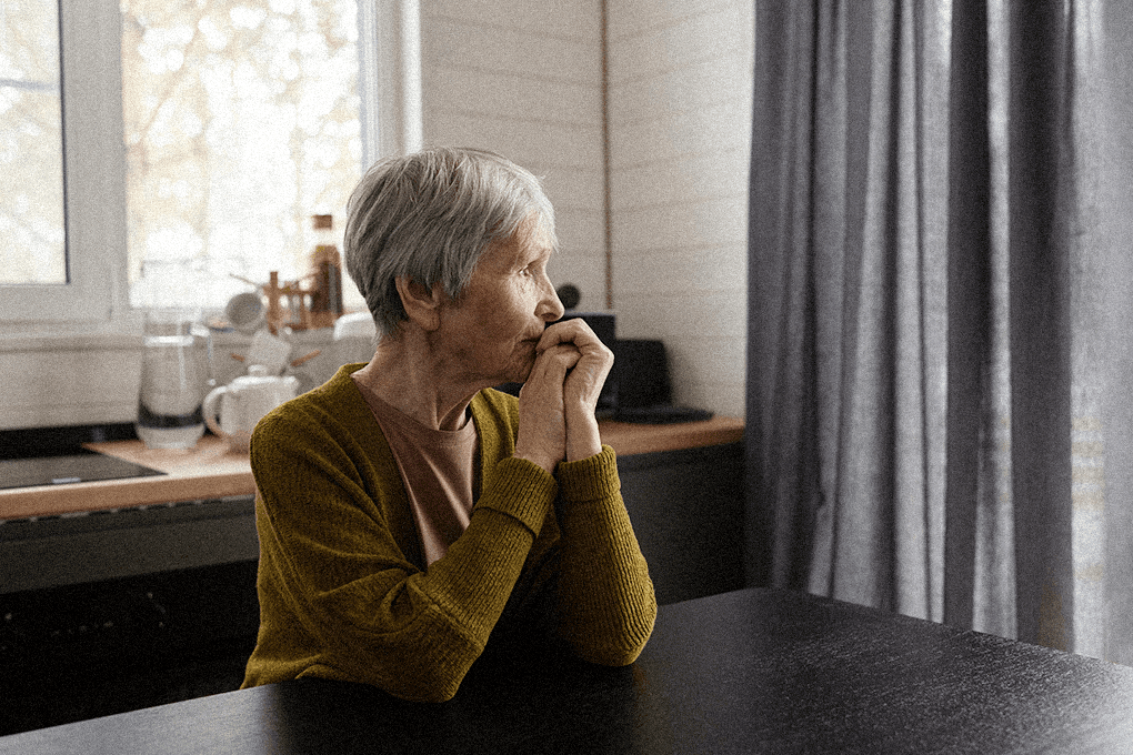 Elderly Woman looking at the window outside