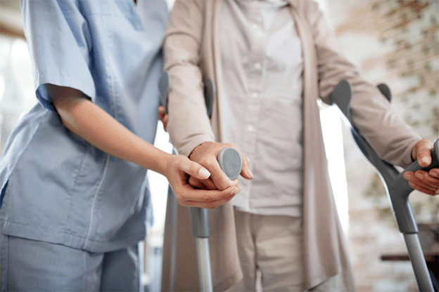 nurse helping old woman with crutches