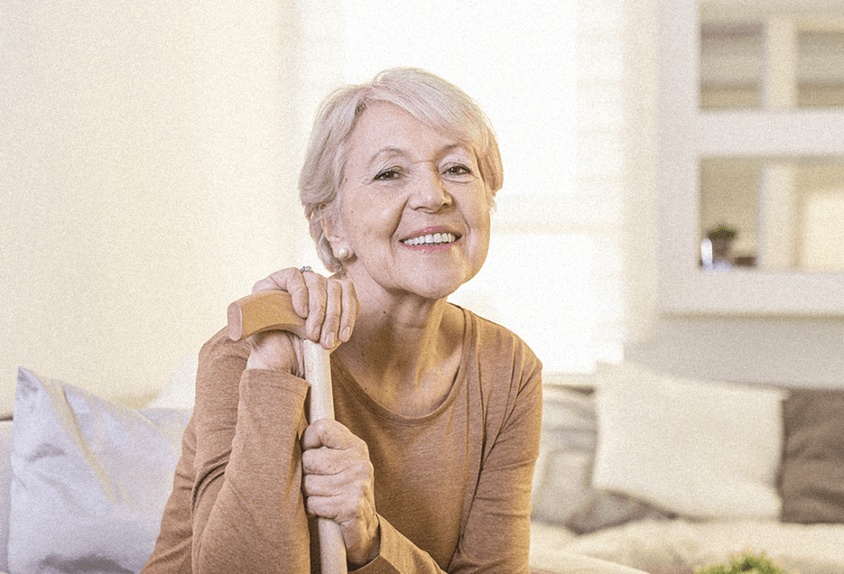 elderly woman sitting with a cane