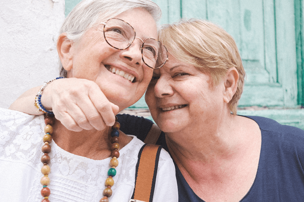 One woman hugging another one by her neck